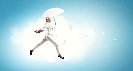 Businesswoman with white umbrella . Mixed mediaの写真素材