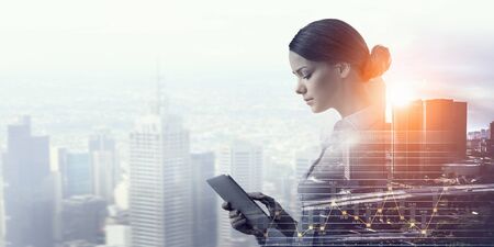 Attractive business lady working on tablet    . Mixed mediaの写真素材