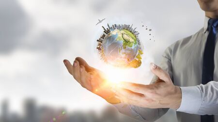 Close up of businessman holding Earth planet in palm.