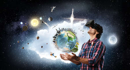 Young excited man in helmet experiencing virtual reality. Elements of this image are furnished by...