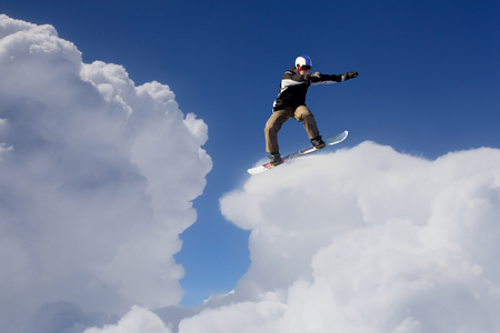 Snowboard rider jumping against blue cloudy skyの写真素材