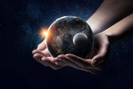 Earth planet in human hands. Elements of this image are furnished by NASA