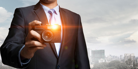 Man with camera in hands . Mixed mediaの写真素材