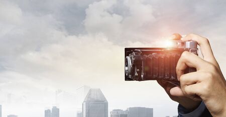 Man with camera in hands . Mixed mediaの写真素材