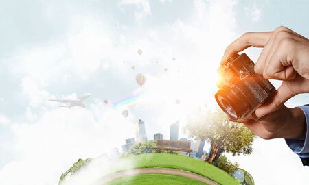 Man with camera in hands . Mixed mediaの写真素材