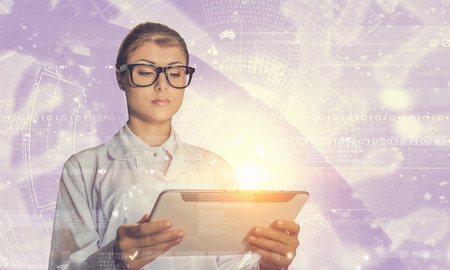 Scientist woman using tablet pc. Mixed media . Mixed mediaの写真素材