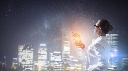 Scientist woman using tablet. Mixed mediaの写真素材