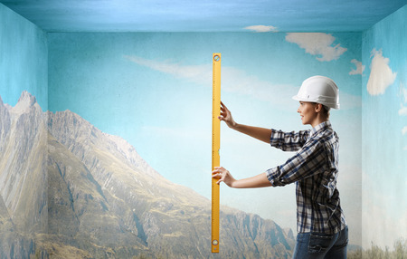 Builder woman taking measures. Mixed mediaの写真素材