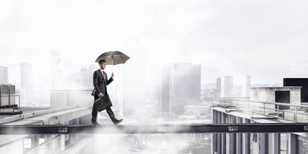 Fearless businessman overcoming difficulty. Mixed mediaの写真素材