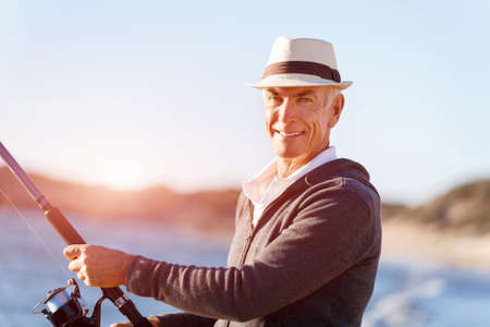 Senior man fishing at sea side