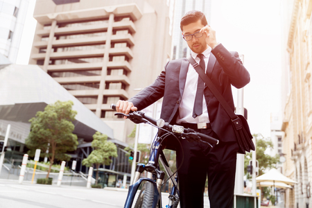 Young businessmen with a bikeの写真素材