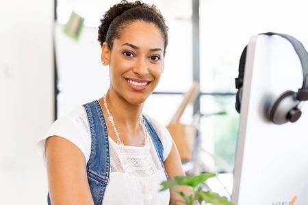Portrait of smiling afro-american office worker sitting in offfice