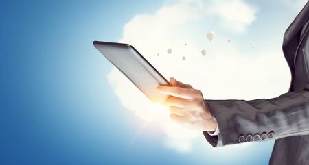 Tablet in woman hand. Mixed media . Mixed mediaの写真素材