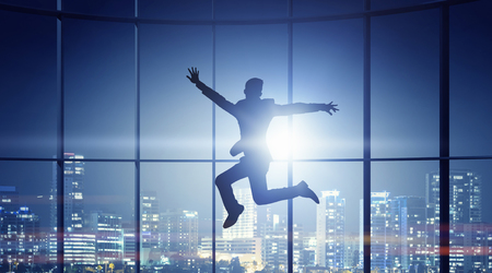 Jumping businessman in office . Mixed mediaの写真素材