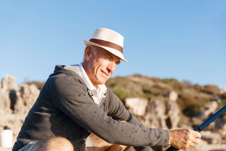 Senior man fishing at sea sideの写真素材