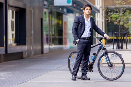 Successful businessman riding bicycleの写真素材