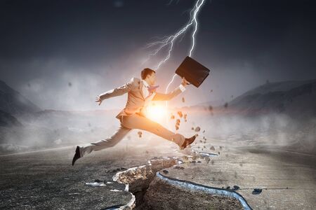 Businessman trying to overcome deep breakの写真素材