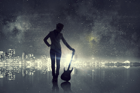 Silhouette of rock babe with electric guitar in hands. Mixed mediaの写真素材