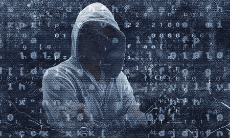 Young man haker wearing hoody on binary code background. Mixed media