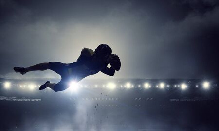 Silhouette of american football player at stadium. Mixed media