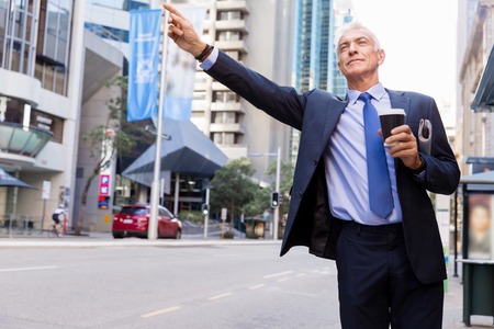 Businessman catching taxi in cityの写真素材