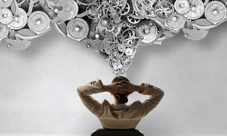 Businesswoman having rest in chair with her arms on headの写真素材