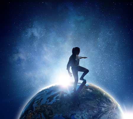 Young woman riding skateboard on Earth planet.の写真素材