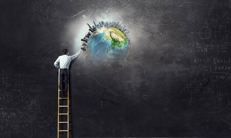 Businessman on ladderの写真素材