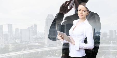 Businesswoman and modern city background. Mixed mediaの写真素材