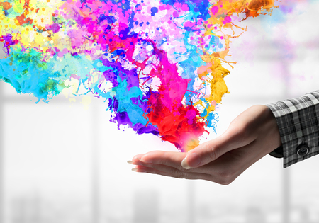 Close up of hand holding splashes of colorful paint. Mixed mediaの写真素材