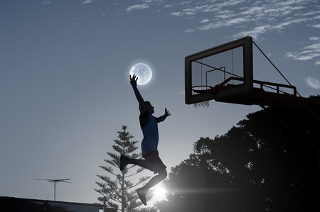 Silhouette of basketball player outdoor throwing ball . Mixed mediaの写真素材