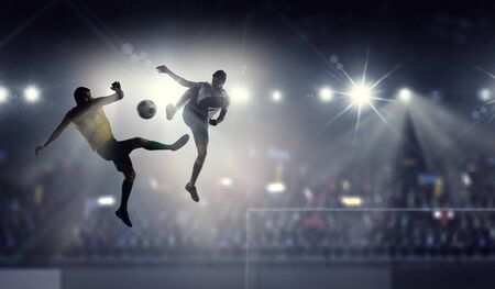 Silhouettes of two soccer players . Mixed mediaの写真素材