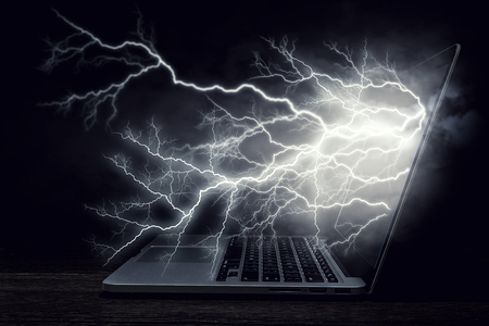Laptop device and lightning flash from screen. Mixed mediaの写真素材