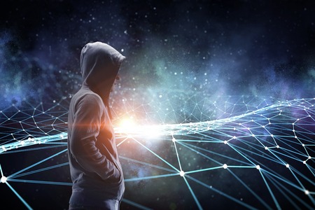 Criminal man wearing hoody against dark background. Mixed mediaの写真素材