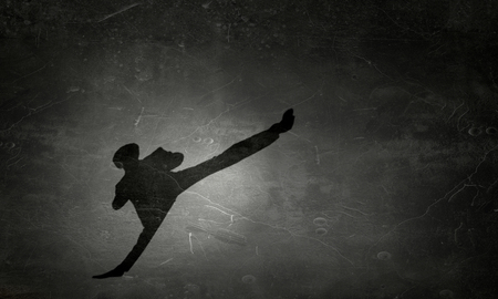 Silhouette of karate man on concrete wall inempty room. Mixed mediaの写真素材