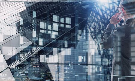 Double exposure of city and businessman on the phone. Mixed media