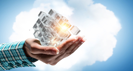 Close of hand holding cube figure as symbol of innovation. 3D renderingの写真素材