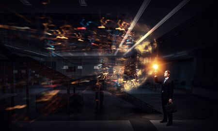 Businessman in dark office and digital work panel. Mixed mediaの写真素材