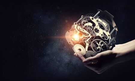 Cogwheel mechanism in hand. Mixed media . Mixed media