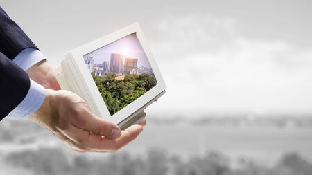 Close of man hands holding on palm retro tv set. Mixed mediaの写真素材