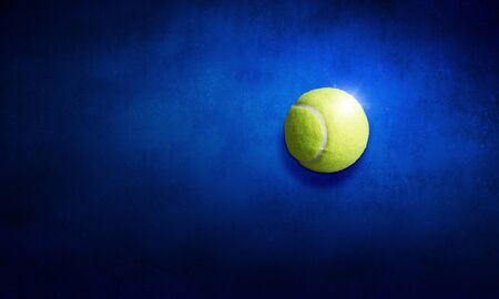 Big tennis yellow ball on blue backgroundの写真素材