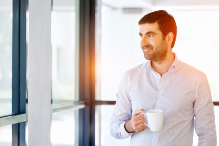Young businessman in office with a mugの写真素材