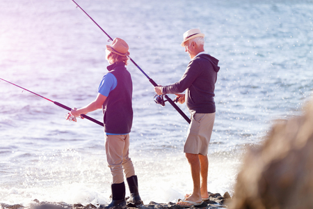 Senior man fishing with his grandsonの写真素材
