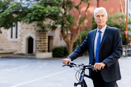 Successful businessman riding bicycleの写真素材