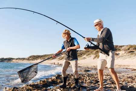 Senior man fishing with his grandsonの写真素材