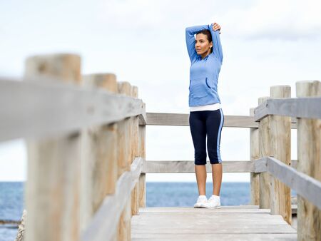Young woman at the beach doing exercises