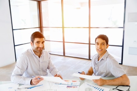 Image of two young business people in officeの写真素材
