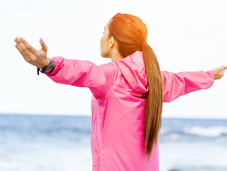 Young woman in sportswear standing at the seasideの写真素材