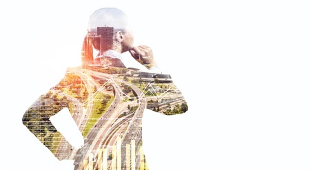 Double exposure of businesswoman talking mobile and cityscapeの写真素材