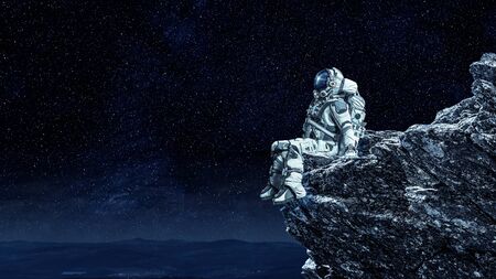 Spaceman on rock edge. Mixed mediaの写真素材